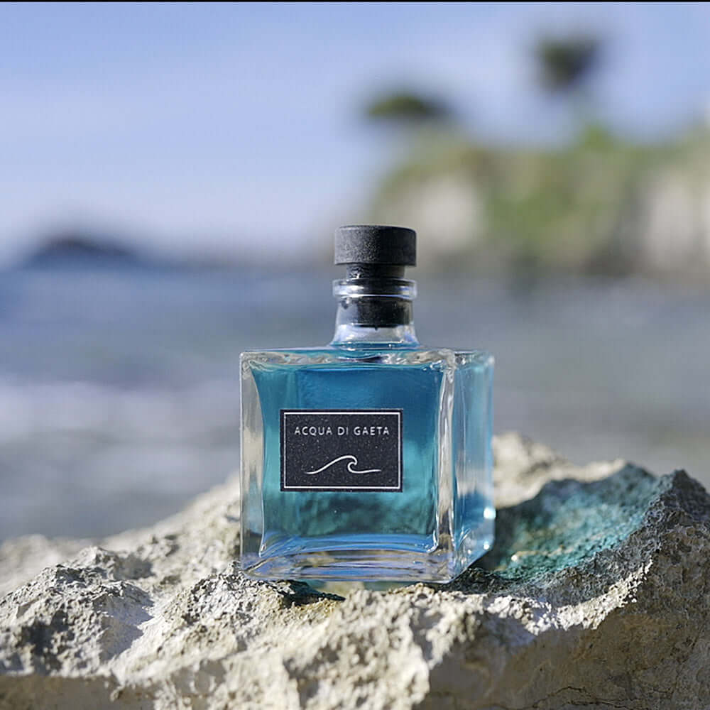 Acqua di Gaeta — Profumatore d’Ambiente 100 ml displayed on a rock by the sea, capturing Mediterranean freshness.
